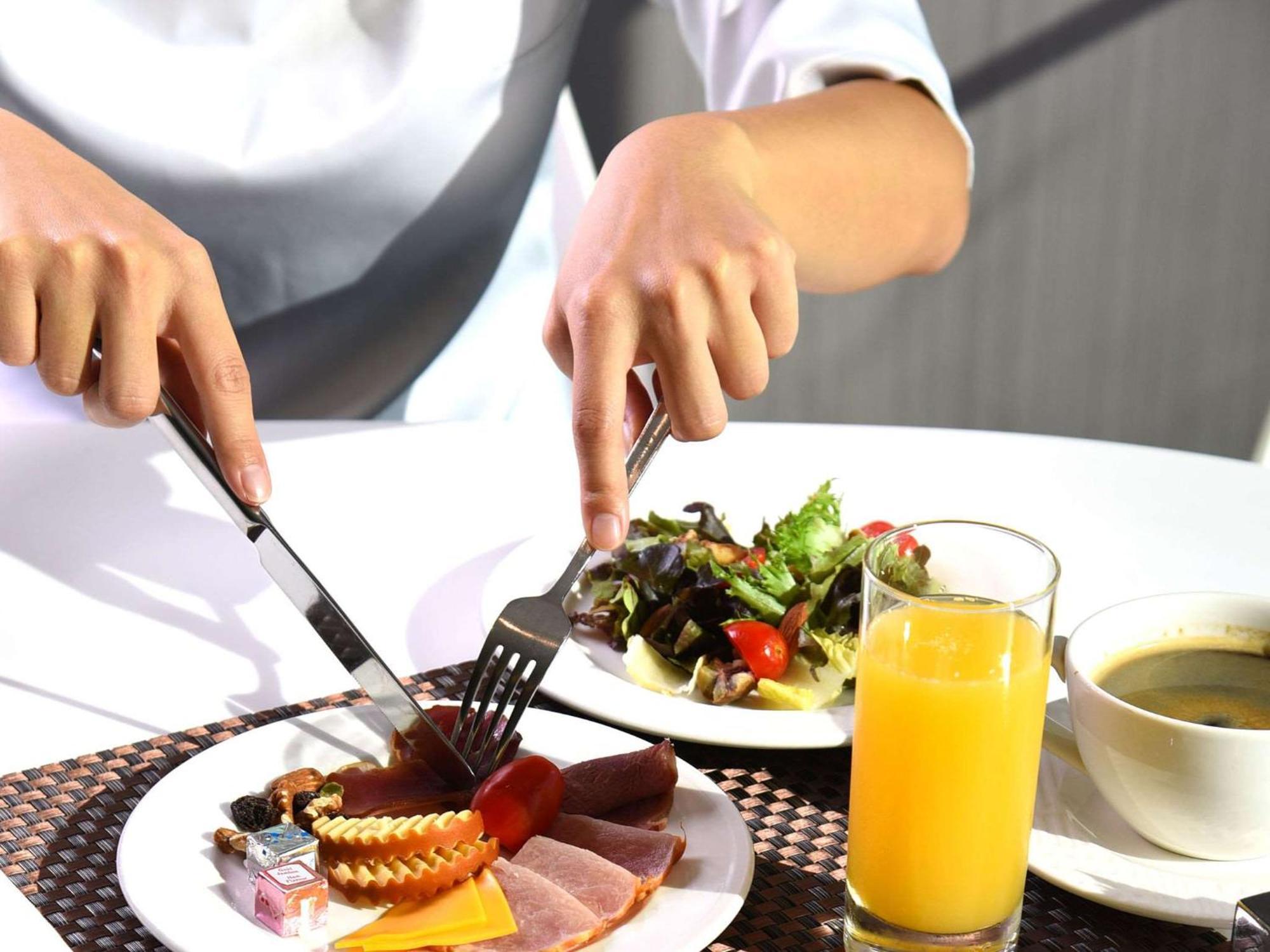 Novotel Taipei Taoyuan International Airport Exterior photo A person eating breakfast